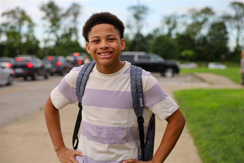 A student wearing a striped shirt smiles